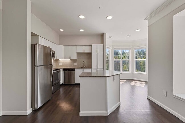 Modern kitchen design with sleek finishes and dark wood flooring