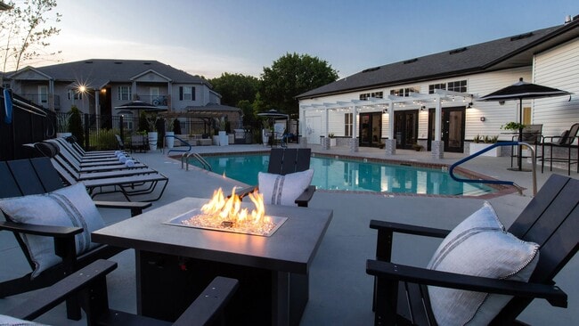 Enjoy the enchanting glow of our community fire pit, creating the perfect atmosphere for evening relaxation under the starry night sky. - Greystone Woods Apartments