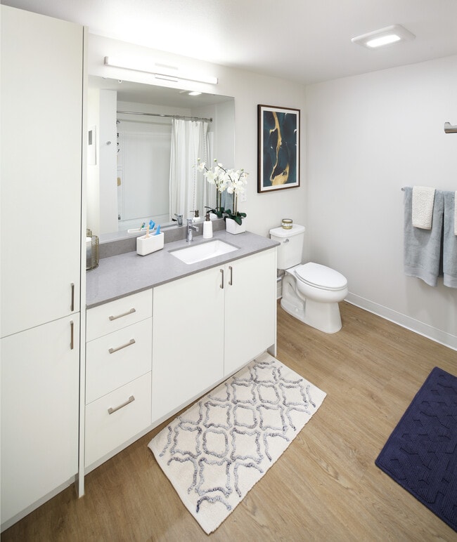 Phase II - Scheme C Bath with white cabinetry, grey quartz stone countertop, and hard surface flooring