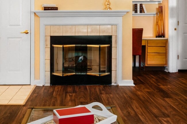 Elegant fireplace, crown molding, and wood-style floors