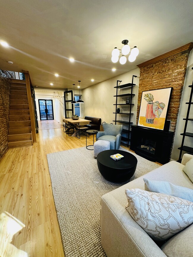 Living room with electric fireplace through to dining area, kitchen, and back patio - 615 S Bambrey St