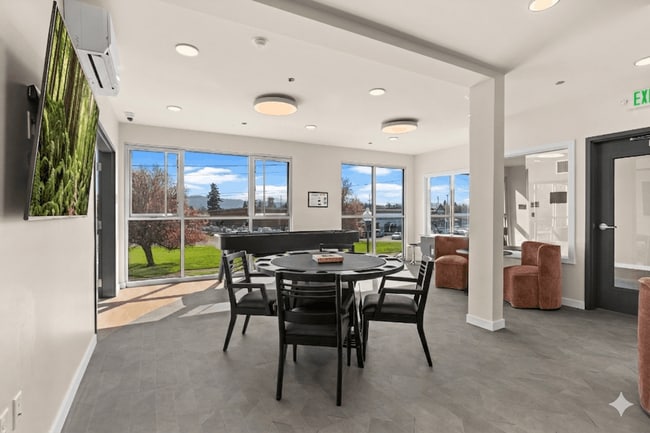 Sumner apartments with a resident lounge featuring game tables, modern seating, and large windows.