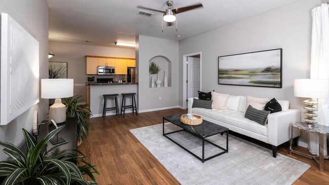 This beautifully designed living room offers an open flow to the modern kitchen, perfect for entertaining and relaxation. - Lakes of Tuscana