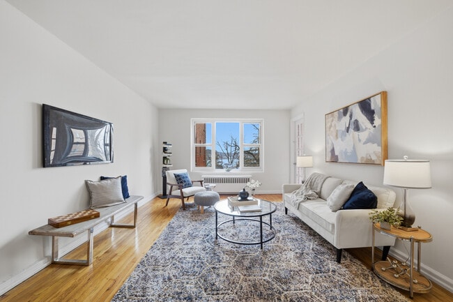 Bright living room with hardwood floors and seamless access to a balcony showcasing the Hudson River - 555 Broadway Unit 4F