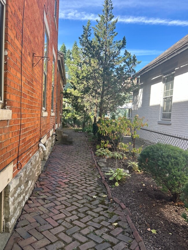 Fenced backyard with original brick sidewalk - 118 E Kossuth St