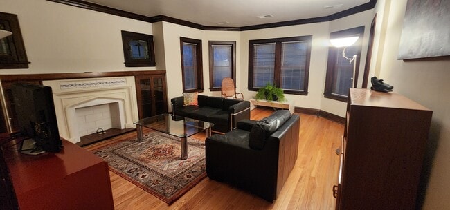 Living Room with leather couch and armchair, rocking chair, glass table, credenza, cabinets, lamps - 2018 Lake St Unit Apt 2