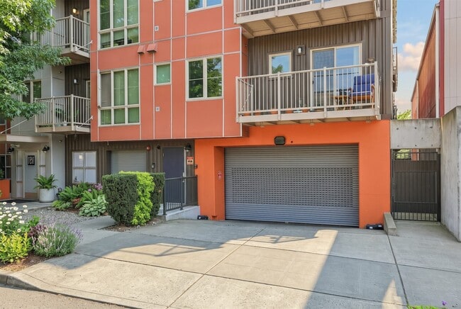 Exterior view of REV Fremont in Seattle featuring modern siding, private balconies, and secure garage parking access.