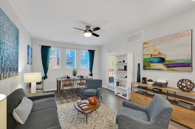 Bright and modern living room with chic decor, featuring cozy seating, a stylish wooden dining table, and vibrant artwork, ideal for both relaxation and entertaining.