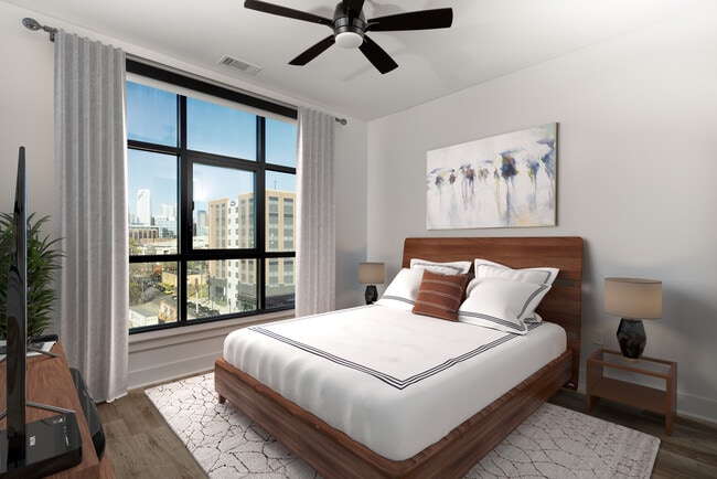Bedroom with hard surface flooring, ceiling fan, and floor-to-ceiling window