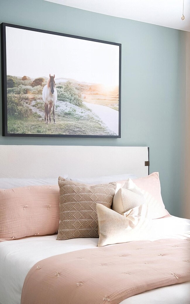 Soft color behind the headboard gives the bedroom its own character.
