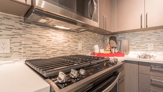 Designer inspired backsplash, under cabinet lighting and gas cooktops - Modera Midtown