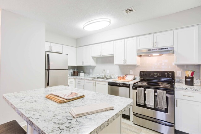 Kitchen with white cabinetry and stainless steel appliances - Avana Collins Creek Apartments