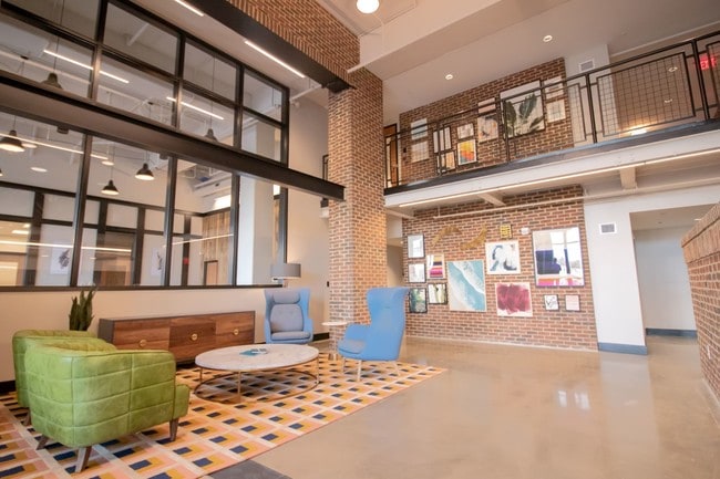 The main lobby at Penstock Quarter apartments in Henrico VA features a two story gallery wall and impressive brick details.