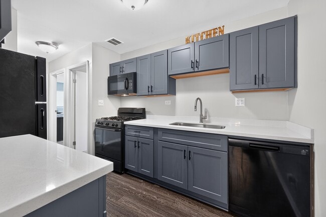 Cook up something great in this stylish kitchen with black appliances and cabinetry at Renaissance at Carol Stream in Carol Stream, IL. - Renaissance at Carol Stream