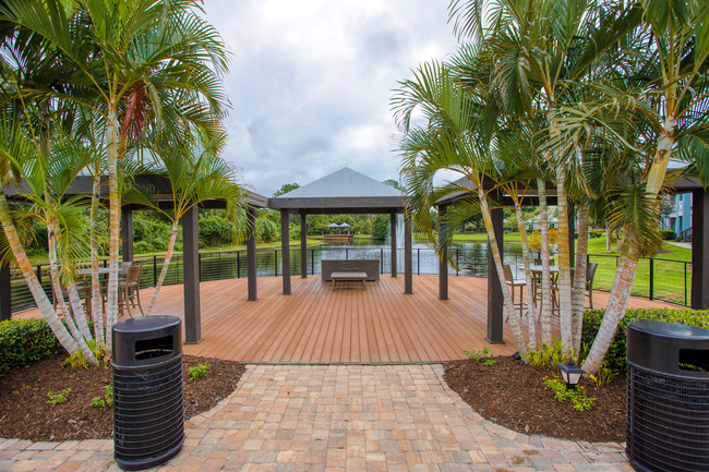 Audubon Village – Lakeside deck with gazebos and seating with a view of the lake. - Audubon Village Apartments