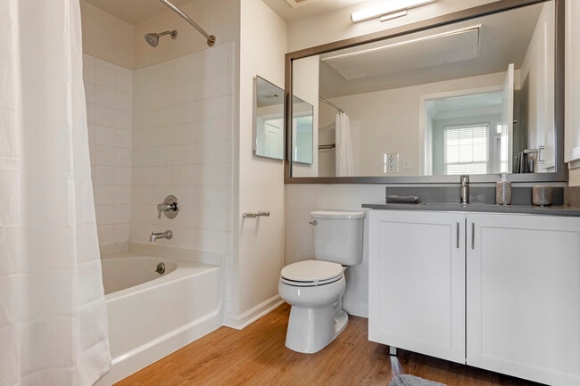 Finish Package II bath with white cabinetry, grey quartz countertops, and hard surface flooring