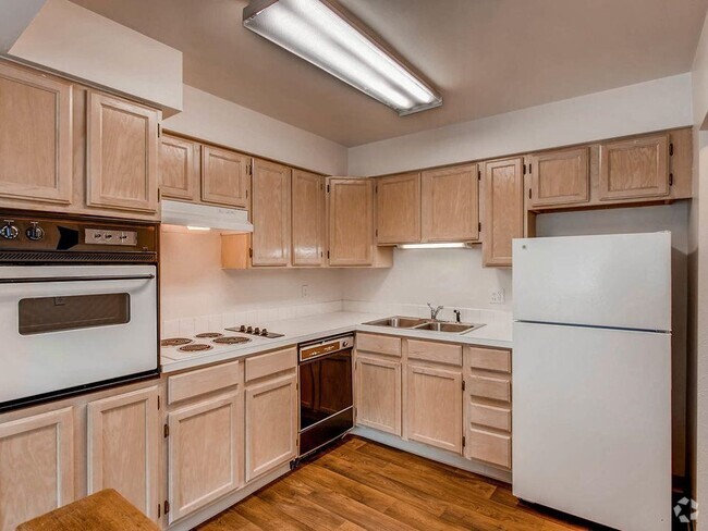 Royal Gardens - Kitchen featuring white appliances, large Formica counter tops, and tan cabinets. - Royal Gardens Rental