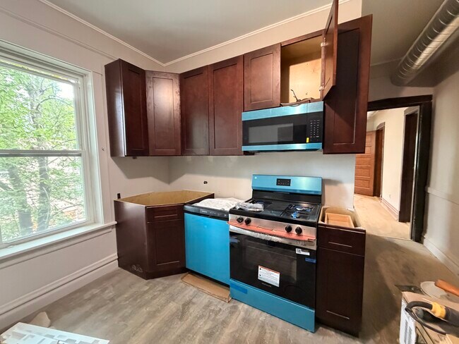 Kitchen install pre-countertop installation. New appliances still have plastic wrap