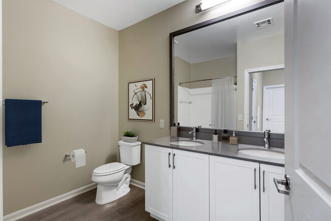 Renovated Package II bath with grey quartz countertops, white cabinetry, and hard surface flooring