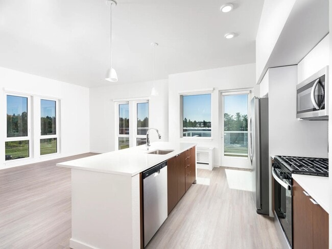 Este apartamento de concepto abierto cuenta con una cocina lista para chef con estufa a gas, elegantes electrodomésticos de acero inoxidable y espaciosos espacios de estar.