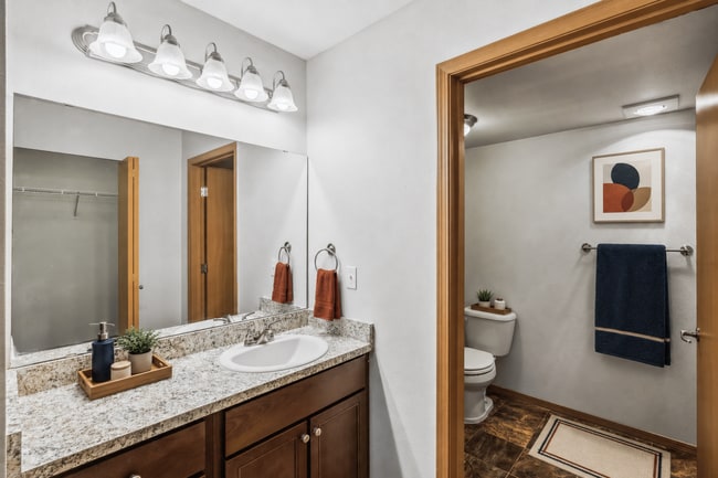 A bright bathroom with generous counter space and a private toilet area.