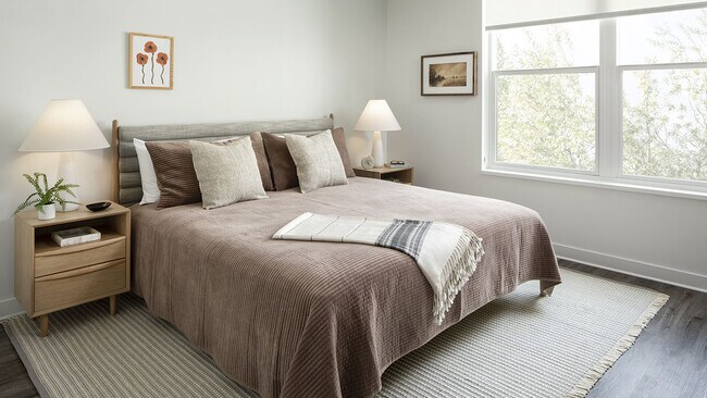 Spacious apartment bedroom with wood floors.