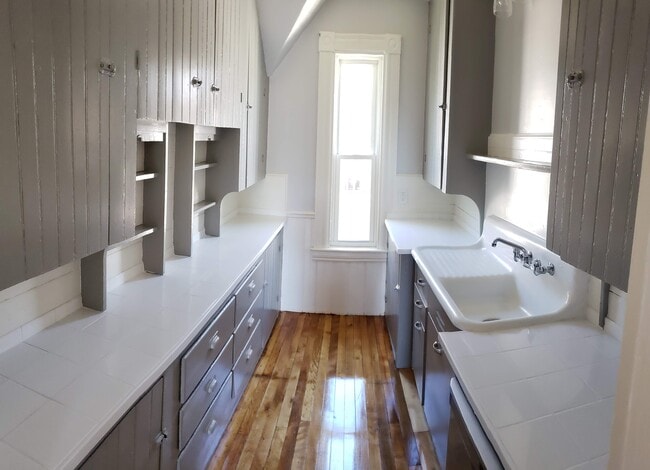 Galley Kitchen has many cabinets, newly installed dishwasher, antique cast iron sink and tin ceilings - 32 Hevey St Unit 3