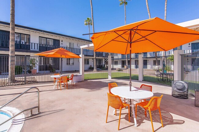 Patio with orange umbrellas and chairs - Miramonte on 3rd