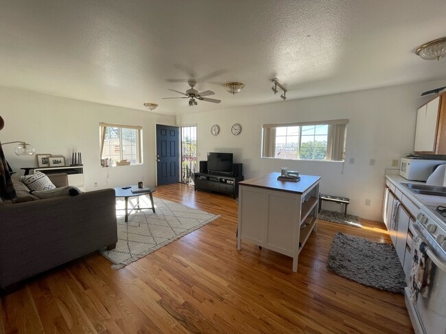 View of open floor plan with living room and kitchen; front door in the background - 3720 Louisiana St Unit 1