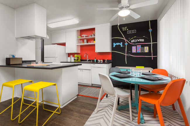 Classic Package II kitchen with white or black appliances, black laminate countertops, white cabinetry, and hard surface flooring (select homes)