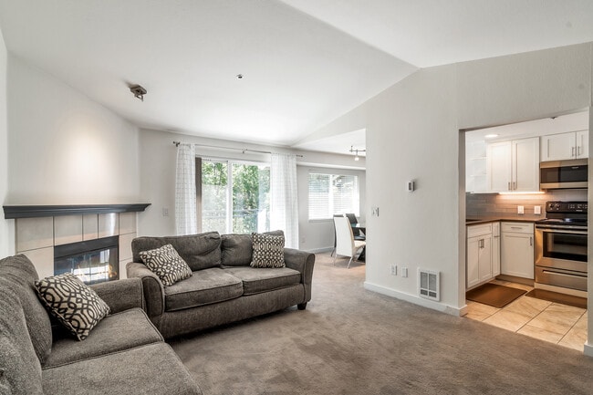 Living room with a view into the kitchen. - 19404 Bothell Way NE Unit B304