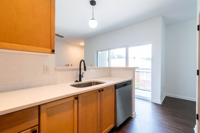 Open kitchen with bar seating, stone countertops and updated appliances