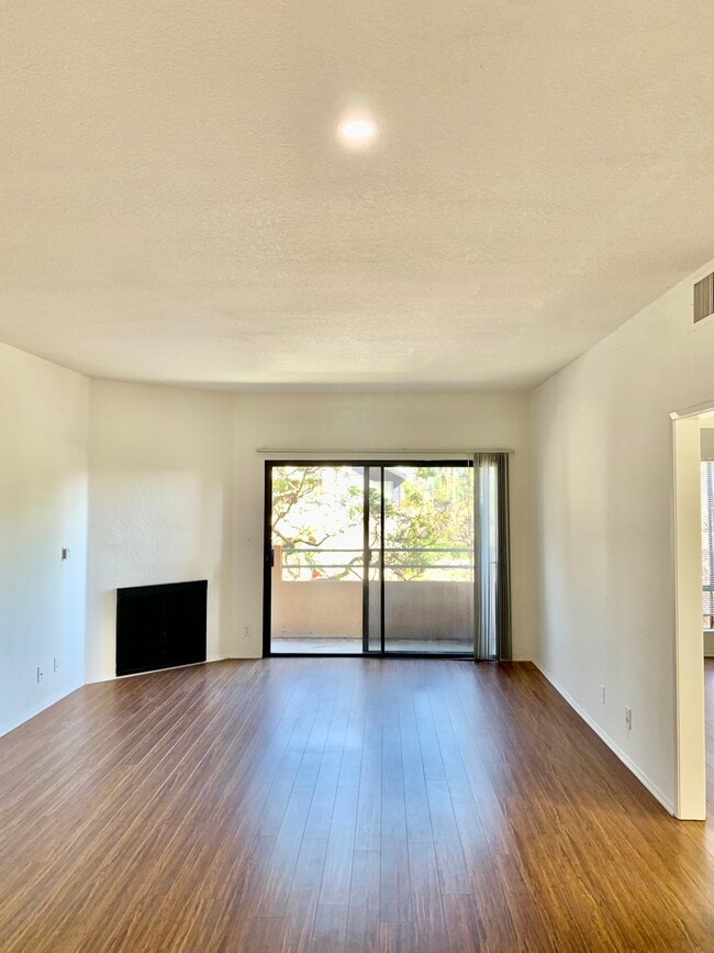 Cozy bright living room with fireplace and private balcony - 3816 Beethoven St Apartments Unit 105