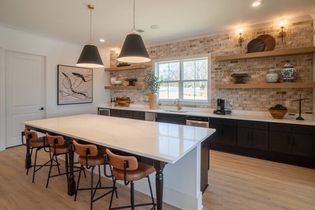 Kitchenette inside the clubhouse with bar seating, mini fridge and sink.