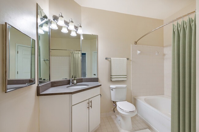 Renovated Package I bath with white cabinetry, grey quartz countertops, and hard surface flooring
