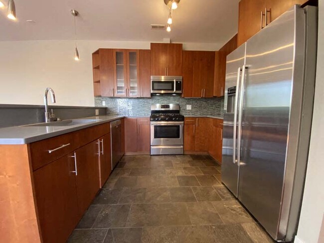 Gorgeous kitchen space with tile flooring and stainless steel appliances - 1635 W Cortland Apartments