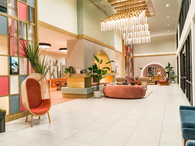 Grand lobby with soaring ceilings, statement lighting, and curated gathering spaces that create an impressive welcome and a vibrant social atmosphere.
