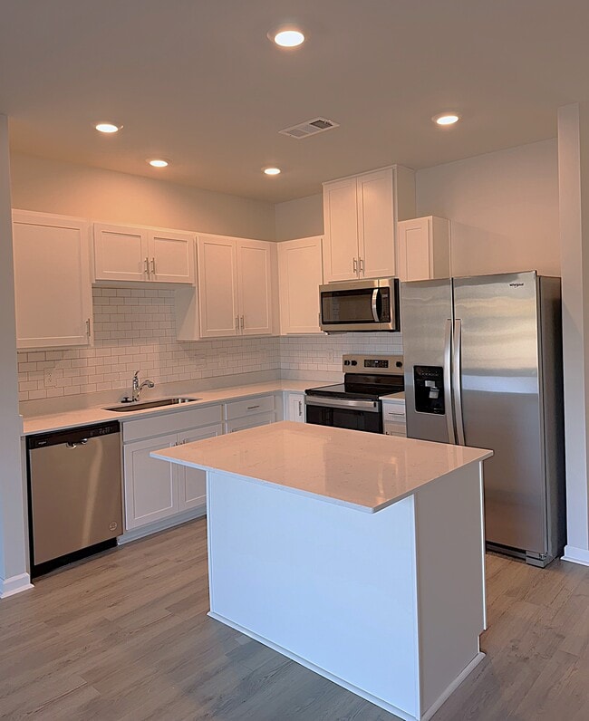 La cocina cuenta con electrodomésticos de acero inoxidable y mucho espacio de almacenamiento, incluyendo una despensa. - 403 Augustine Dr