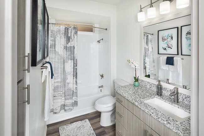 Bathrooms feature wood grain cabinets and framed mirrors