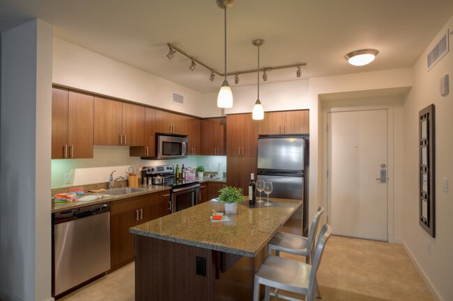 Classic Package I kitchen with brown speckled granite countertops, espresso cabinetry, stainless steel appliances, and hard surface flooring