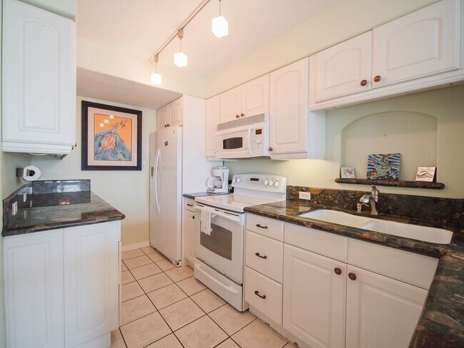 Full kitchen with pans, plates, and dinnerware.