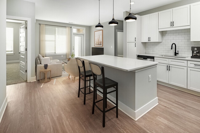 Modern kitchen with white cabinetry, white quartz countertop, stainless steel appliances, and hard surface flooring