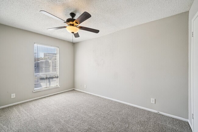 Step into comfort at The Riley Apartments. This spacious bedroom features natural light and a modern ceiling fan, perfect for relaxation. Enjoy a welcoming atmosphere in a community you’ll love. Schedule your tour today to see your new home!