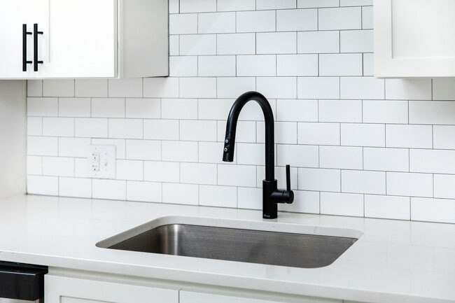 Kitchen with white quartz countertops and tile backsplash