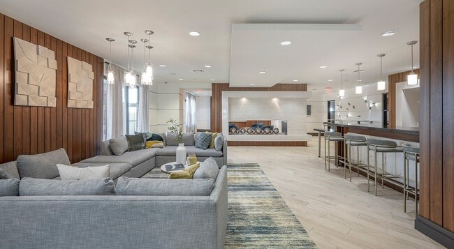 Bar stools and an entertainment kitchen sit at one end of the lounge.