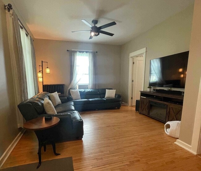 Spacious living room with ample seating, large TV, and seasonal window AC. - 1901 -2301 Fillmore Street NE Minneapolis, MN 55418