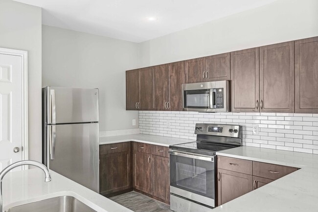 Upgraded kitchens include ENERGY STAR® stainless steel appliances, quartz countertops, and stylish tile backsplash. - Alister Sunset Valley