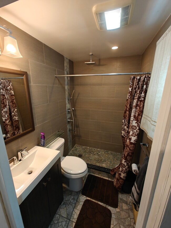 Baño en la planta baja con ducha de efecto lluvia y suelo de piedra turquesa. - 29 Peter Way