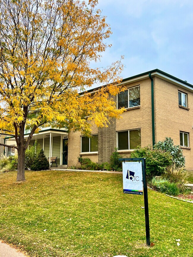 Explore el atractivo exterior de este encantador apartamento de ladrillo, rodeado de naturaleza. - Oak Street Apartments