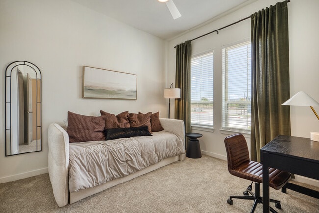 Bright bedroom with a large window and ceiling fan at Sageland Flats at Brooks